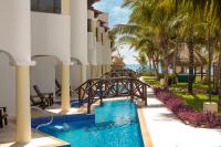 a resort with a bridge over a pool and palm trees at Hidden Beach Resort Au Naturel Adults Only Catamarán, Cenote & More Inclusive in Akumal