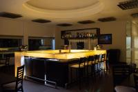 a bar in a restaurant with chairs around it at HOTEL AEROPUERTO MORELIA in Álvaro Obregón