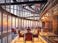 a restaurant with tables and chairs and large windows at J Hotel, Shanghai Tower - Above All Else, Overlooking the Bund in Shanghai