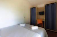 a bedroom with a large white bed and a chair at Belambra Clubs Capbreton - Les Vignes in Capbreton