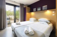 two beds in a hotel room with towels on them at Belambra Clubs Capbreton - Les Vignes in Capbreton