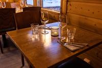 una mesa de madera con tres copas de vino. en Arctic River Resort, en Ivalo