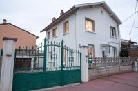 a white house with a green gate at DIFY Chalet a la ville - Parilly in Vénissieux