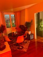 an orange living room with orange chairs and a table at Escapade jacuzzi in Caen