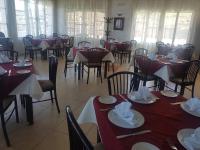 un comedor con mesas y sillas con servilletas. en Restaurante Cafe El Balcon, en Beni Enzar