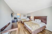 a hotel room with two beds and a television at Baymont by Wyndham Panama City Beach in Panama City Beach