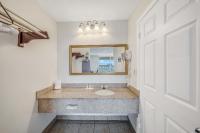 a bathroom with a sink and a mirror at Baymont by Wyndham Panama City Beach in Panama City Beach