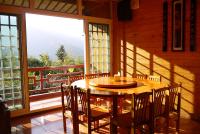 a wooden table and chairs in a room with a large window at Kingtaiwan Hotel in Lugu Lake