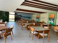 ein Restaurant mit Tischen und Stühlen in einem Raum in der Unterkunft Porto Beach Resort - Mana Beach Experience in Porto De Galinhas