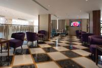 泰布克Najm aris hotel的大堂设有 ⁇ 制地板和紫色椅子