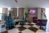 泰布克Najm aris hotel的带沙发、椅子和电视的客厅