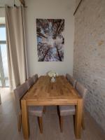 a dining room table with chairs and a painting on the wall at Gite Oliveira&#39;s in Ury