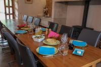 een lange houten tafel met stoelen en borden met eten erop bij Au pays de Jacquou : Chambre d’hôtes et table d’hôtes in Fossemagne