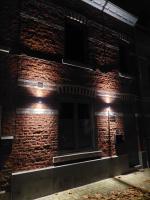 a brick building with lights on it at night at Viator Tongeren in Tongeren