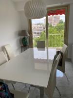 a white dining room table with white chairs and a window at NICE BAIE DES ANGES in Nice