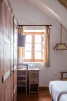 a bedroom with a desk and a bed and a window at Hotel Tugasa Convento San Francisco in Vejer de la Frontera