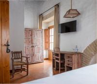 a room with a table and chairs and a television at Hotel Tugasa Convento San Francisco in Vejer de la Frontera