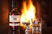 una botella de alcohol junto a un vaso de whisky en Knockendarroch Hotel, en Pitlochry