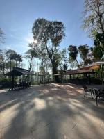 Un parque con bancos, un refugio y árboles. en Machaan Wilderness Lodge Nagarahole, en Srimangala