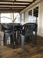 a black table and chairs on a porch at M&amp;R location in Les Mathes