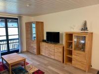a living room with a tv and a entertainment center at Ferienwohnung am Walchensee in Walchensee