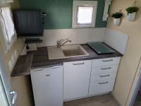 a small kitchen with a sink and a tv at La paillote idyllique in Faverolles-sur-Cher
