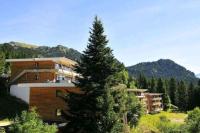 a large building with a tree in front of it at Charmant T2 proche des pistes superbe vue in Chamrousse