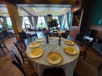 a dining room with a table with yellow plates on it at Resort Strzelnica in Kochcice