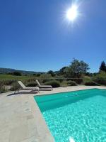 a swimming pool with the sun in the sky at Gite Himaya - Vaison la Romaine in Vaison-la-Romaine