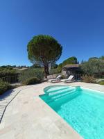 a swimming pool with blue water in a yard at Gite Himaya - Vaison la Romaine in Vaison-la-Romaine