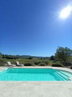 a swimming pool with blue water in a yard at Gite Himaya - Vaison la Romaine in Vaison-la-Romaine