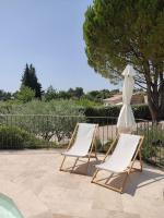 two chairs and an umbrella next to a pool at Gite Himaya - Vaison la Romaine in Vaison-la-Romaine