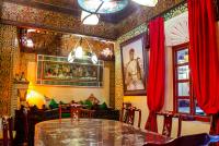 een eetkamer met een glazen tafel en rode gordijnen bij Riad Esmeralda in Marrakesh