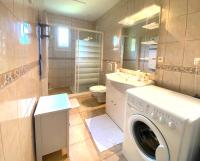 a bathroom with a washer and a washing machine in it at Charmante Villa familiale à SAINTE CECILE PLAGE in Camiers