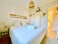 a bedroom with a large white bed and a lamp at Charmante Villa familiale à SAINTE CECILE PLAGE in Camiers