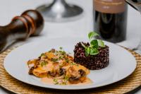 a plate of food on a table with a bottle of wine at La Fontaine in Hunedoara