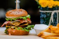 a hamburger and french fries on a table at La Fontaine in Hunedoara