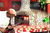 Een man die voor een pizzaoven staat. bij Brooklyn Guesthouses in Pretoria