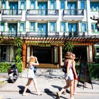 Tres mujeres caminando por una calle frente a un bar de fuego en Fuse Old Town Hoi An, en Hoi An