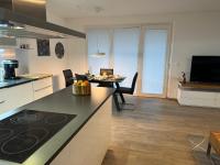 a kitchen and living room with a counter and a table at Ferienwohnung Fischerweg in Bodensdorf