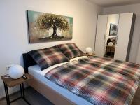 a bedroom with a bed and a painting of a tree at Ferienwohnung Fischerweg in Bodensdorf