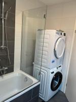 a bathroom with a washing machine and a washer at Ferienwohnung Fischerweg in Bodensdorf