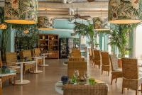 um restaurante com mesas, cadeiras e plantas em Botania Relais & Spa - The Leading Hotels of the World em Ischia