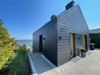 a small black house with a view of the ocean at Grafit in Mechelinki