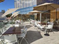 un patio con mesas, sillas blancas y sombrillas en Hotel GRALTA, en Jalostotitlán