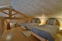 two beds in a room with wooden ceilings at Gite de groupe &quot;L&#39;Unisson&quot; Domaine La Rose des Vents in Castelnau-sur-lʼAuvignon