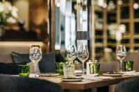 a table with wine glasses and plates on it at Grand Tirolia Kitzbühel - Member of Hommage Luxury Hotels Collection in Kitzbühel