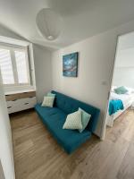 a living room with a blue couch and a bed at Duplex en plein centre in Propriano