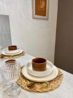 una mesa con dos platos y tazas y un vaso en Studio avec Balcon proche Gare, en Bourg-en-Bresse