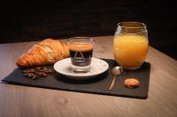 a tray with a glass of orange juice and a croissant and a cup at Hostellerie LE PANEL in Mandelieu-La Napoule